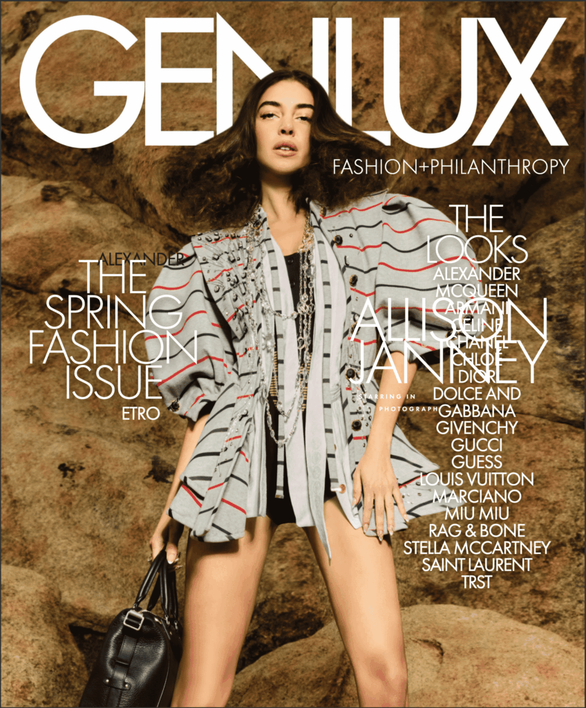 Magazine cover featuring a model in a gray striped jacket holding a handbag, against a stone backdrop.